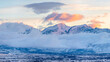 Pano A picture of a mountain with clouds touching it at dawn