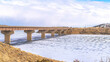 Pano White snow-covered river with a bridge and a white cloudy sky background