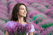 Lovely young woman wearing purple dress and posing in magenta lavender field closeup; professional retouch.