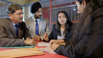 Poster - Sikh man wearing the black turban with his colleagues from India in the workplace having a meeting