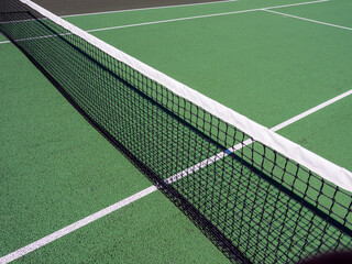 Wall Mural - High angle shot of a dividing net in a tennis field on a sunny day