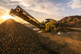 Fototapeta  - Heavy and mobile machinery in a quarry to transform stone into construction material