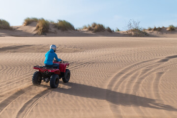 Poster - Scenic view of a person driving a red Quad Bike at the beach in Essaouira, Morocco