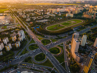 Wall Mural - Aerial view from a drone of a highway road in the city at sunset