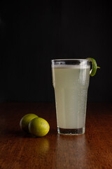 Poster - Vertical shot of a glass of refreshing drink with lime on a dark background