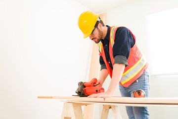 Wall Mural - Carpenter with protective gear cutting wood