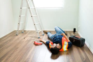 Wall Mural - Hispanic electrician having a work accident