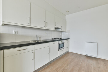 Canvas Print - Empty white kitchen with laminate flooring and closets