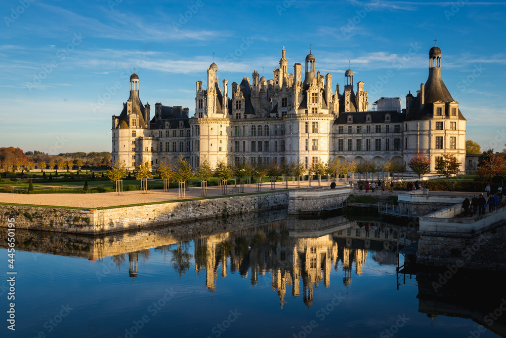 Chateau de Chambord, France reflecting in the water on a sunny day - obrazy, fototapety, plakaty 