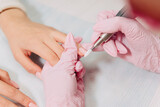 Fototapeta Zwierzęta - Manicure process. The master polishes the nail using an automated machine. Drill polish remover.