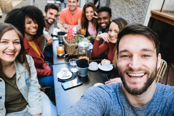 Canvas Print - Multiracial friends doing selfie while eating and drinking coffee at vintage bar outdoor - Focus on right man face