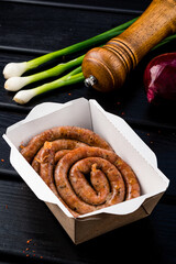 Sticker - Grilled sausages summer picnic dish, twisted in a circle on a dark wooden background