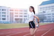 © EduLife Photos - A young beautiful Asian woman in sports outfits doing stretching before workout outdoor in the park in the morning to get a healthy lifestyle. Healthy young woman warming up outdoors