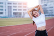 © EduLife Photos - A young beautiful Asian woman in sports outfits doing stretching before workout outdoor in the park in the morning to get a healthy lifestyle. Healthy young woman warming up outdoors