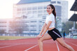 © EduLife Photos - A young beautiful Asian woman in sports outfits doing stretching before workout outdoor in the park in the morning to get a healthy lifestyle. Healthy young woman warming up outdoors