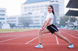 © EduLife Photos - A young beautiful Asian woman in sports outfits doing stretching before workout outdoor in the park in the morning to get a healthy lifestyle. Healthy young woman warming up outdoors