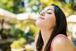 Healthy young adult woman breathing fresh air in the park - Side view portrait of handsome lady relaxing in outdoors terrace - Healthcare lifestyle and wellness