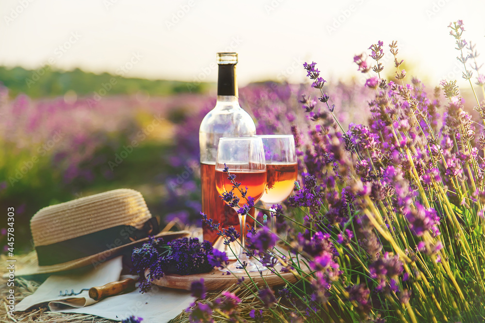 Wine in glasses. Picnic in the lavender field. Selective focus. - obrazy, fototapety, plakaty 