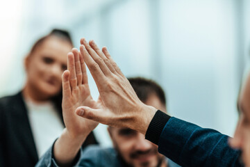 Wall Mural - close up. young employees giving each other a high five