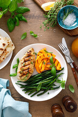 Grilled chicken breast with green beans and butternut squash, top view