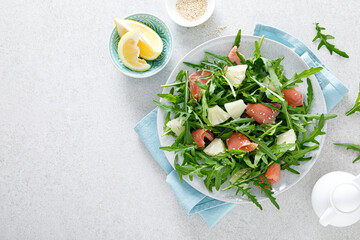 Wall Mural - Salted salmon and arugula salad with fresh pineapple, top view