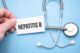 the doctor's hands holds a business card with the text of Hepatitis b with one hand and the other points to the text.