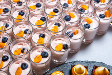 Dessert in cups of yogurt, blueberries and cherry tomatoes.