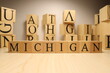 The word Michigan was created from wooden letter cubes. Cities and words.