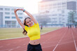 © EduLife Photos - A young beautiful Asian woman in sports outfits doing stretching before workout outdoor in the city stadium  in the morning to get a healthy lifestyle. Healthy young woman doing excercise