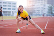 © EduLife Photos - A young beautiful Asian woman in sports outfits doing stretching before workout outdoor in the city stadium  in the morning to get a healthy lifestyle. Healthy young woman doing excercise