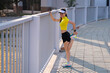 © EduLife Photos - A young beautiful Asian woman in sports outfits doing stretching before workout outdoor in the city stadium  in the morning to get a healthy lifestyle. Healthy young woman doing excercise