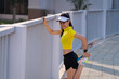 © EduLife Photos - A young beautiful Asian woman in sports outfits doing stretching before workout outdoor in the city stadium  in the morning to get a healthy lifestyle. Healthy young woman doing excercise