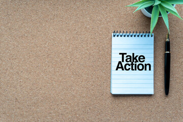 TAKE ACTION text with notepad, decorative plant and fountain pen on wooden background. Business and copy space concept..