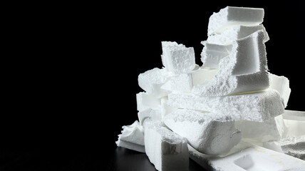 A pile of Styrofoam trash ready to be recycled for reuse. Shot on a black background