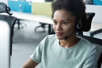 Wall Mural - How can I help you? Beautiful call center workers in headphones are working at modern office