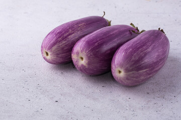 Wall Mural - eggplant or brinjal, vegetables on a white surface, closeup