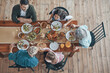 © gstockstudio - Top view of multi-generation family communicating and smiling while having dinner together