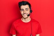 © Krakenimages.com - Young hispanic man wearing call center agent headset looking positive and happy standing and smiling with a confident smile showing teeth