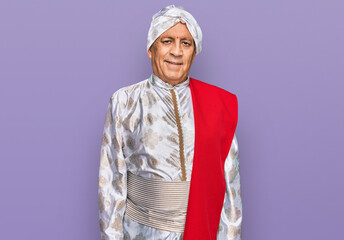 Canvas Print - Senior hispanic man wearing tradition sherwani saree clothes relaxed with serious expression on face. simple and natural looking at the camera.