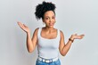 © Krakenimages.com - Young african american girl wearing casual style with sleeveless shirt clueless and confused with open arms, no idea and doubtful face.