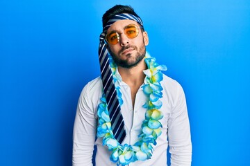 Canvas Print - Young hispanic businessman wearing party funny style with tie on head relaxed with serious expression on face. simple and natural looking at the camera.