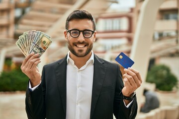 Canvas Print - Young hispanic businessma holding american dollars and credit card at the city.