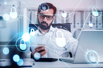 Poster - Beard businessman is browsing the Internet in smartphone on workplace. Laptop on working desk, blue glowing information protection padlock icons. Concept of cyber security and data storage