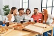 © Krakenimages.com - Group of young people smiling happy and hugging eating italian pizza at home.