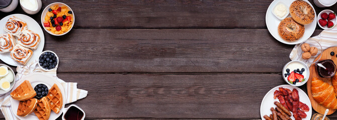 Leinwandbilder - Breakfast or brunch double border on a dark wood banner background. Overhead view. Variety of sweet and savory food items.