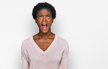 Wall Mural - Young african american girl wearing casual clothes angry and mad screaming frustrated and furious, shouting with anger. rage and aggressive concept.