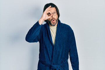 Sticker - Middle age caucasian man wearing bathrobe and glasses doing ok gesture shocked with surprised face, eye looking through fingers. unbelieving expression.