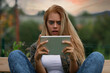Horrified young woman staring wide-eyed at her tablet