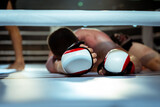 Fototapeta  - Defeated boxer lies in the ring