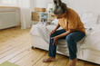© shurkin_son - Elderly woman have pain in knee. Mature female suffer with trick knee sitting on bed at home, cozy bedroom interior. Growing old, take care of your health, health problems concept